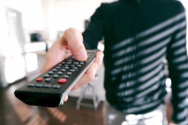 Man Points Remote Control at TV