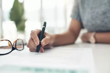 Closeup shot of an unrecognisable businesswoman going through paperwork in an office