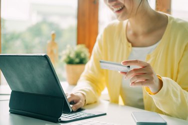 Woman using laptop and credit card for online shopping.