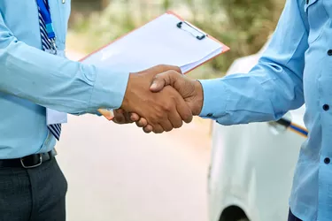 Auto loan deal handshaking close up between car loan agent and taxi driver