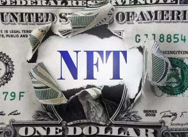 NFT ( Non-Fungible Token ) text in a torn dollar bill