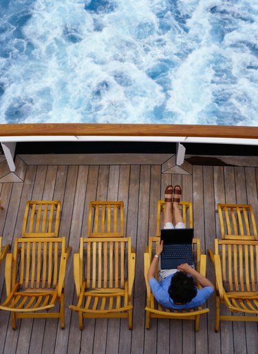 Woman Typing on a Laptop on a Cruise Ship Deck