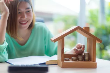 woman piling up change in house bank