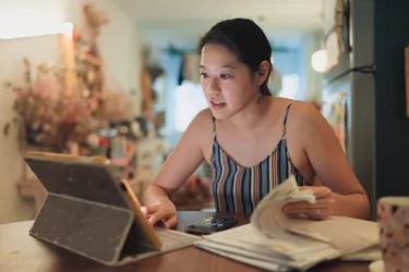 young woman at computer with printouts