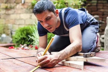 Young man building a backyard deck