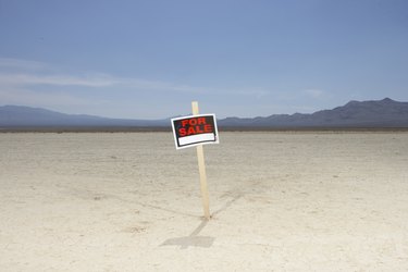 'For sale' sign in dry lake bed