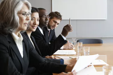 Executives in conference room reading documents, side view