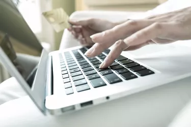 Woman holding a credit card and using computer, online shopping