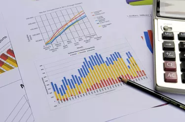 business charts and graphs with pen and calculator