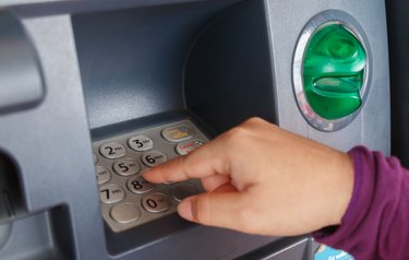 ATM close-up with woman hand
