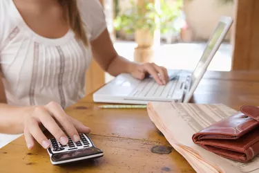 Woman with calculator and laptop