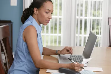 Woman paying bills online at home