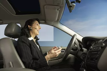 Businesswoman driving and talking on a headset
