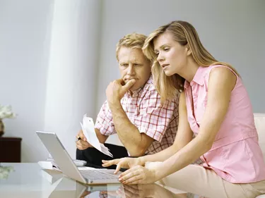 side profile of a mid adult couple looking at a laptop