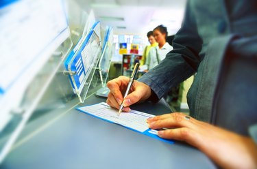 view of a woman filling a form at a counter
