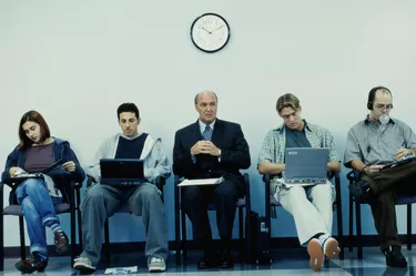 Business executives sitting in a row operating laptops