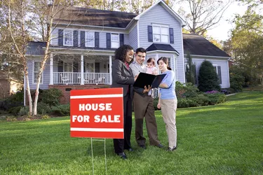 A real estate agent talks to a young family about the suburban home for sale