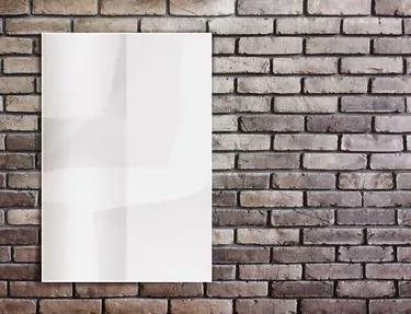 Template- White crumpled  Poster on grunge brick wall and leave