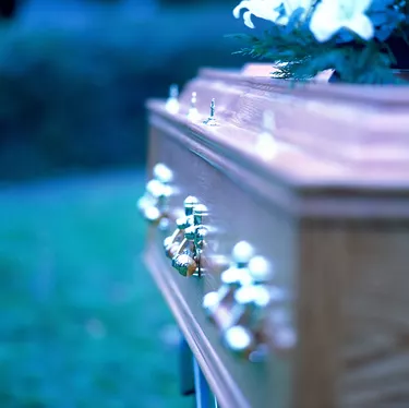 close-up of the side of a coffin with brass handles