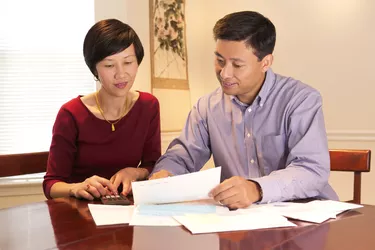 A couple sits at the table going over their finances and bills