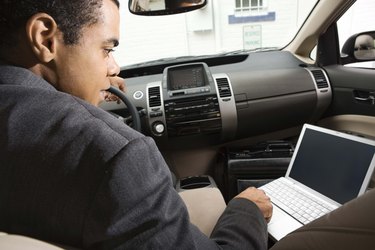 Businessman in car using laptop