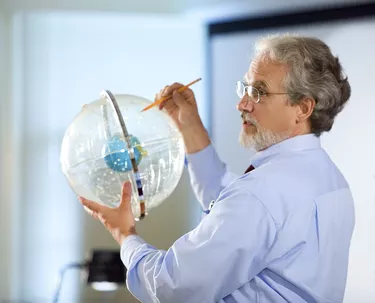 Professor holding astronomical globe