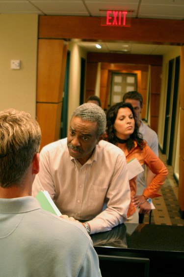 Group of business executives standing in a row at a bank counter