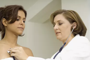 Female doctor examining a mid adult woman with a stethoscope
