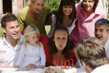 Woman blowing out candles at party