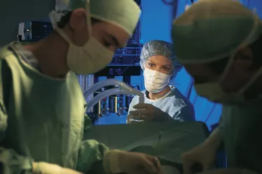 Anesthesiologist with others in operating room