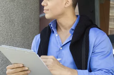 Young man writing on a clipboard