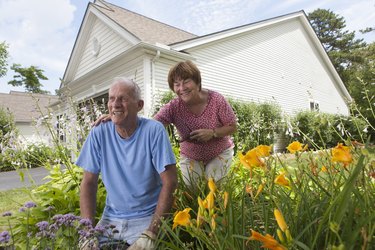 Senior couple preparing to plant flowers in garden