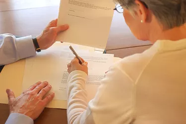 Woman signing paperwork