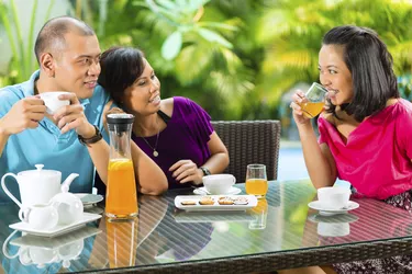 Asian friends having coffee on home porch