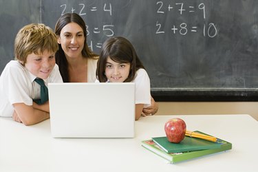 Teacher and children looking at laptop