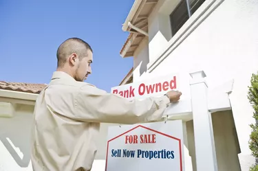 Young man putting up 'for sale notice'