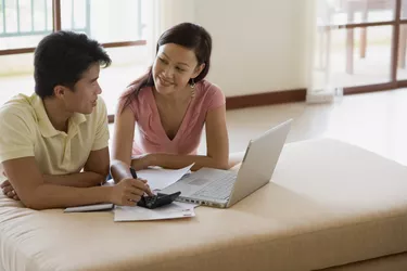 Man and woman doing finances on laptop