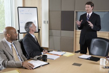 Businessman talking to executives during meeting in boardroom