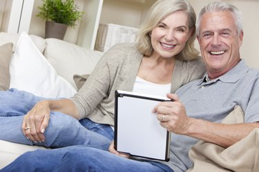 Happy Senior Man & Woman Couple Using Tablet Computer