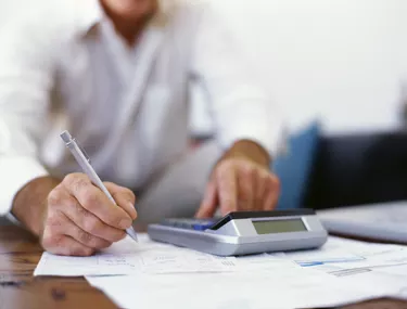 mid section view of a businessman using a calculator in an office