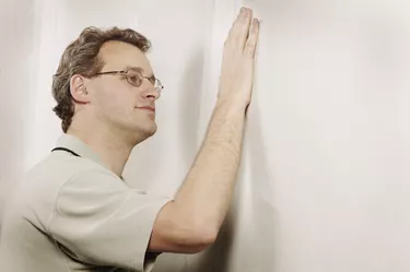 Man checking the smoothness of a wall