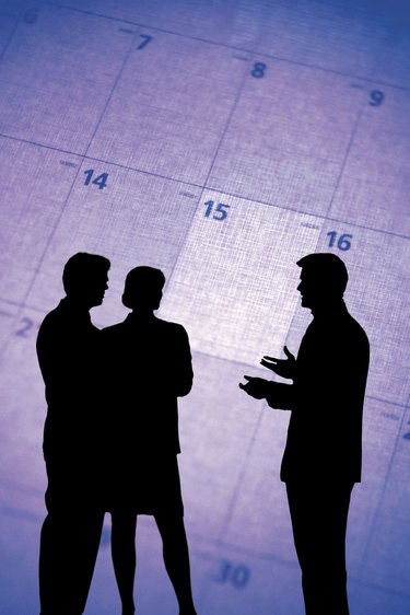 Composite of silhouette of businesspeople and calendar
