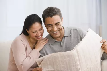 Hispanic couple reading newspaper