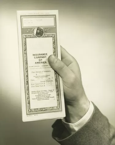 Businessman holding insurance policy, close-up of hand, (B&W)