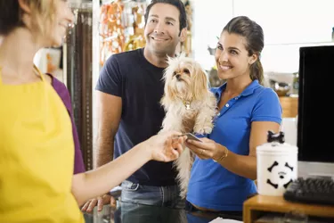 Owners with dog paying groomer