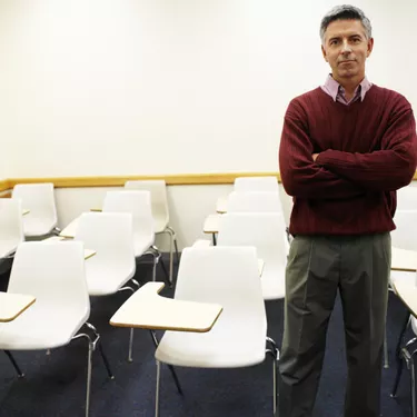 portrait of an elderly man standing in a classroom
