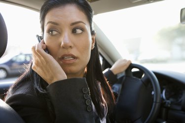 Businesswoman on mobile phone while driving car