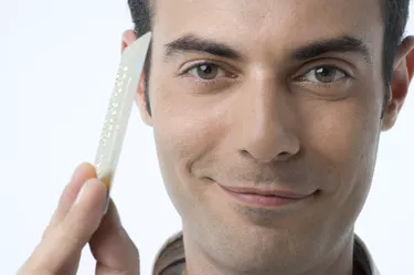 Portrait of young man holding credit card