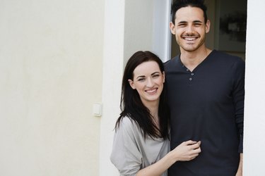 happy young couple welcome in new house at door entrance