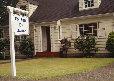 For Sale sign on front lawn of house